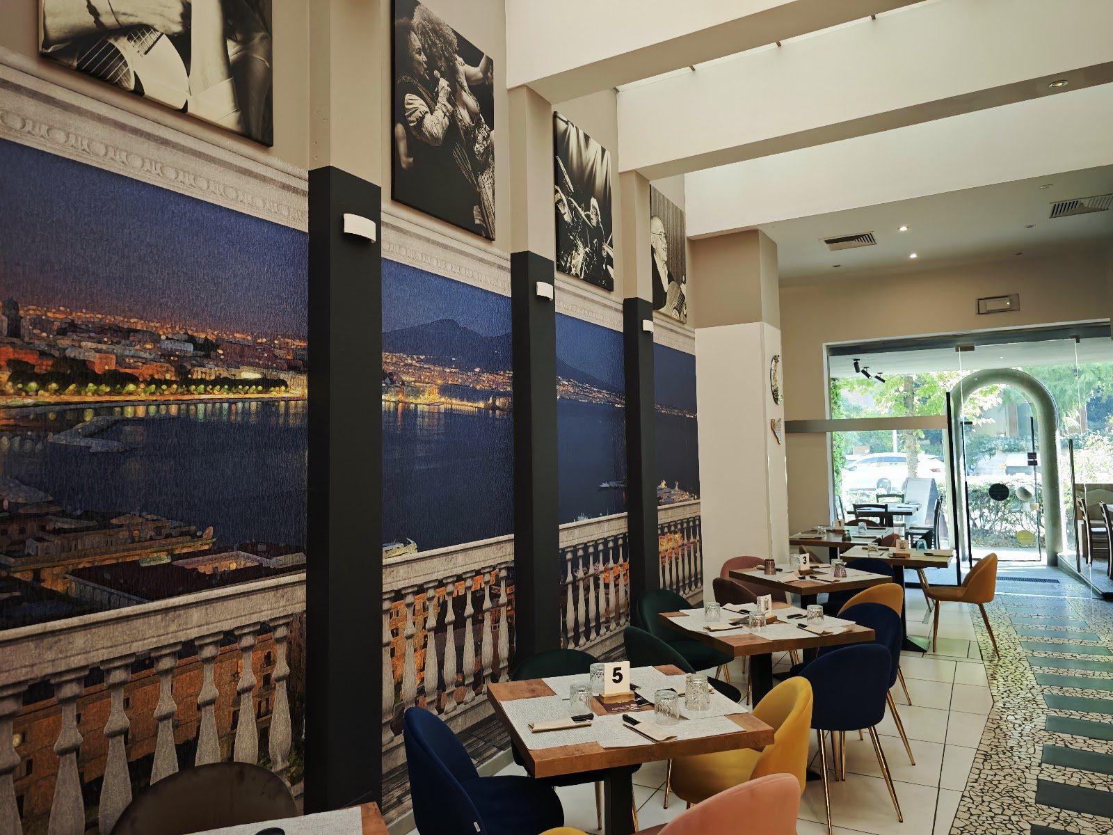 La sala della Pizzeria Da Carmelo: una parete intera con il golfo di Napoli illuminato di notte, visto da una balaustra